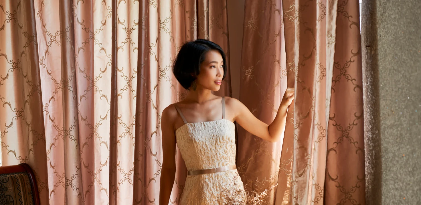 lady looking out of her made to measure curtains